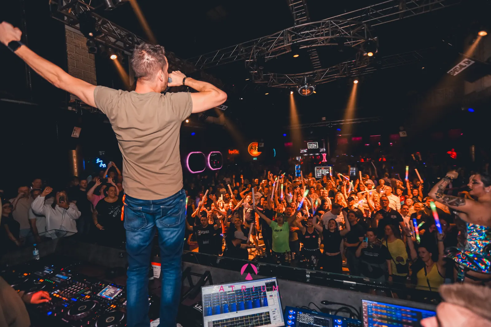 Special D. with arms spread in front of a packed club