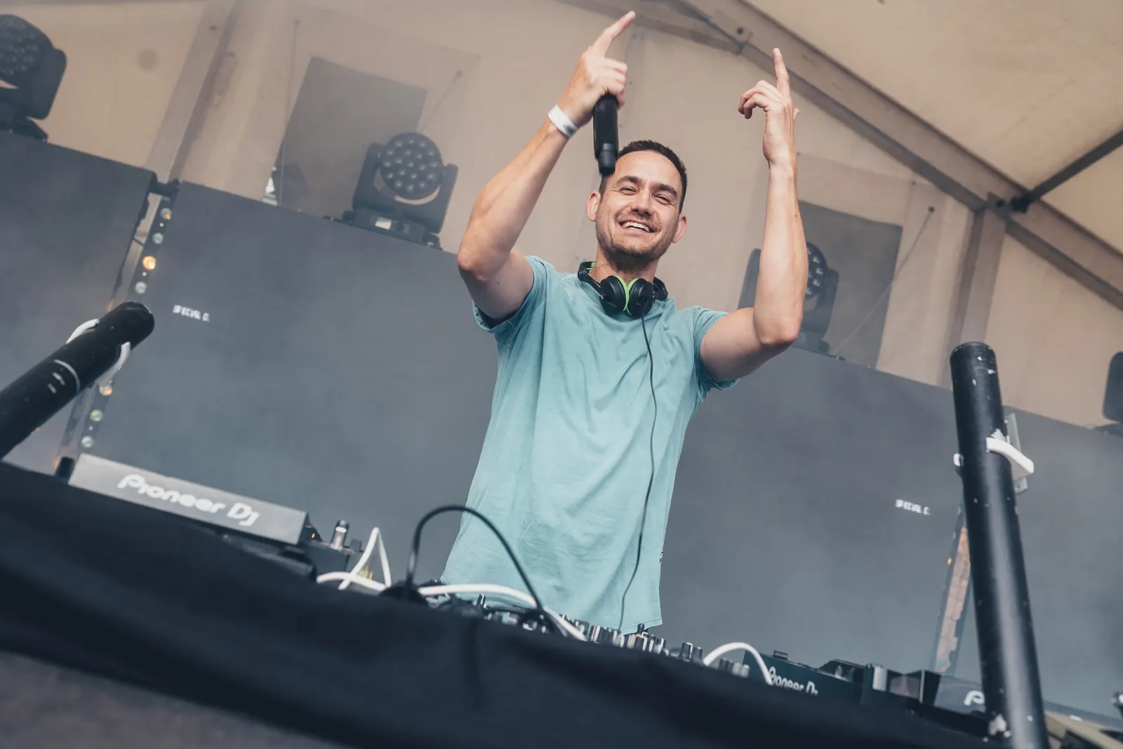 Special D. raising both arms behind the decks
